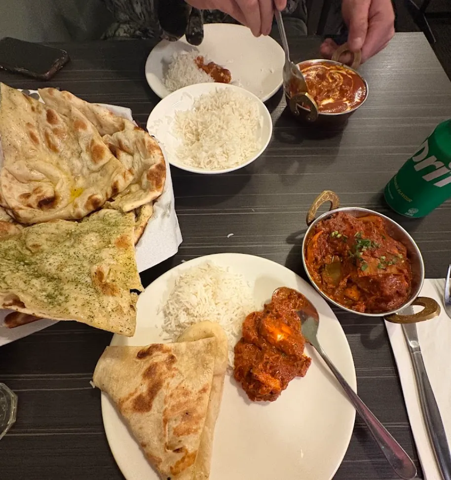 A table spread of naan, rice and curries