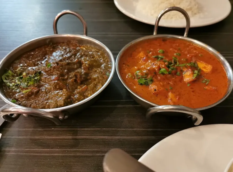 Two curries served in balti dishes